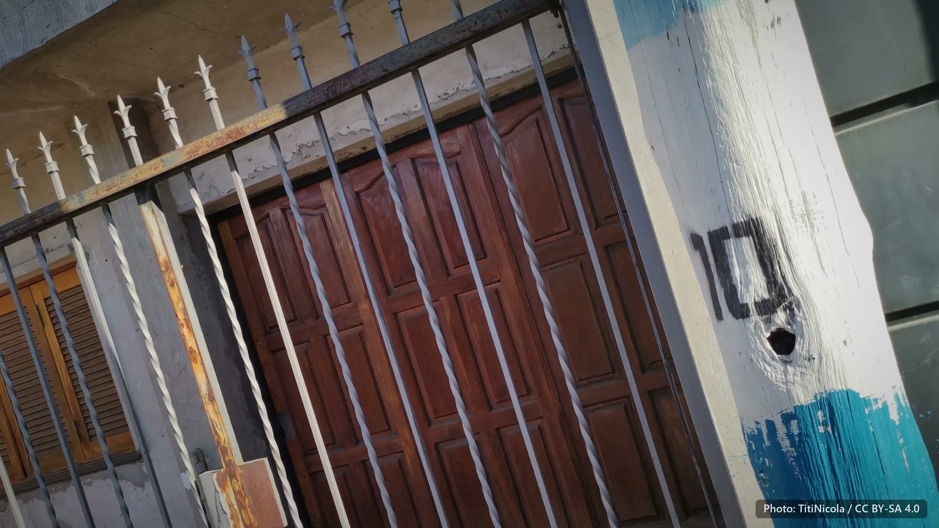 An iron gate and a painted post with a hand-painted 10.
